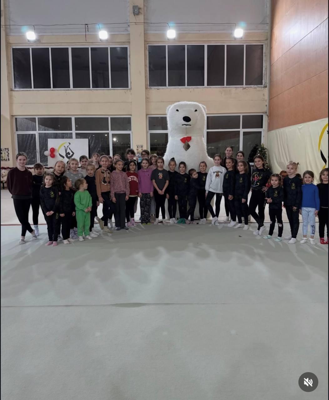Мечката на детско парти в спортна зала с деца